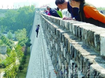 女子正在攀爬中华门城墙。王路宪