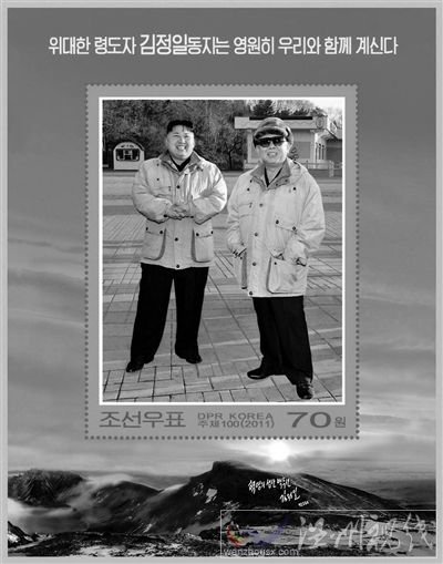 30日，朝鲜发行纪念金正日的邮票小型张2枚。其中一枚邮票的中央是金正日与金正恩在一起的照片，上端写着“伟大领导者金正日同志永远和我们在一起”。 新华社发