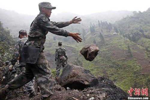 四川芦山地震太平镇钟晶村一处悬崖，战士们正在清理塌方石块