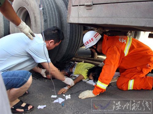 救援人员为压在车轮下的女孩进行输液