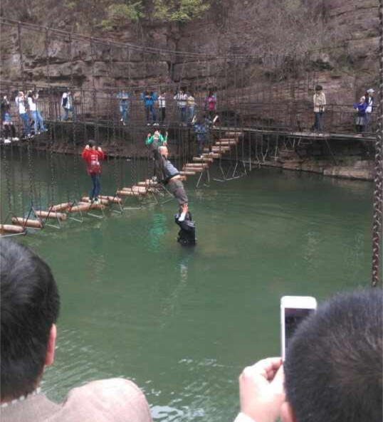 洛阳龙潭峡景区工作人员让游客踩肩过河