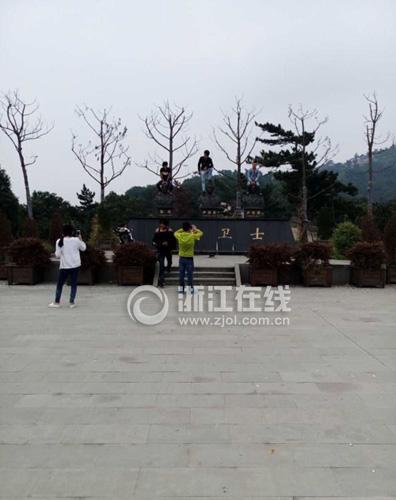男子脚踩消防烈士铜像拍照