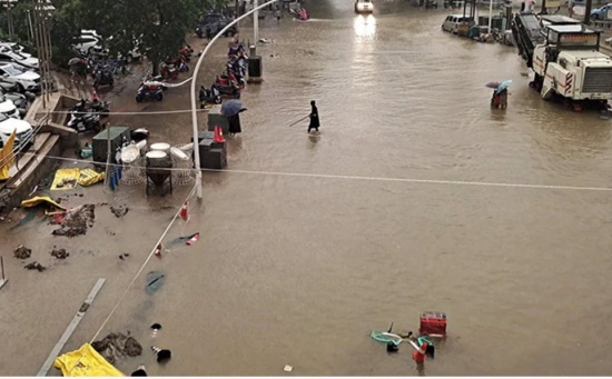 郑州暴雨过后，人们沿着街道趟过洪水。