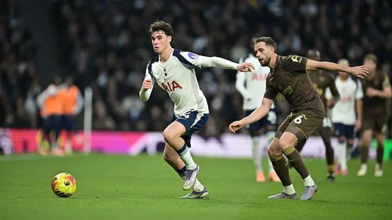 托特纳姆热刺队的阿奇·格雷带球摆脱了布伦特福德队的乔丹·亨德森